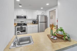 a kitchen with a sink and a stainless steel refrigerator at Handsome 2BR Condo with Gorgeous Views in Sugar Mountain! condo in Sugar Mountain