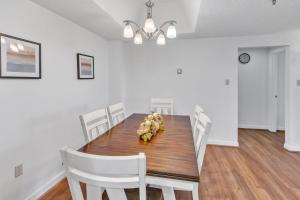 a dining room with a wooden table and white chairs at Handsome 2BR Condo with Gorgeous Views in Sugar Mountain! condo in Sugar Mountain