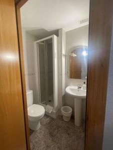 a bathroom with a toilet and a sink at Hostal Cumbre in Zaragoza