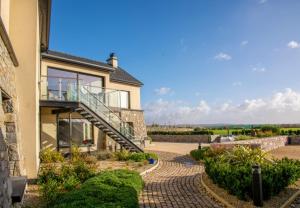 a house with a balcony and a walkway at Sruthan Pier House in Carraroe