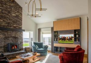 a living room with a fireplace and a tv at Sruthan Pier House in Carraroe