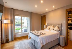 een slaapkamer met een groot bed en een groot raam bij Sruthan Pier House in Carraroe