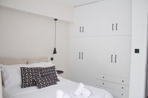 1 dormitorio blanco con 1 cama y armarios blancos en Ermis Mini Suite # 01, en Chalkida
