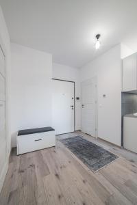 格但斯克的住宿－RentPlanet - Apartament przy Stoczni，白色的客房设有长凳和桌子