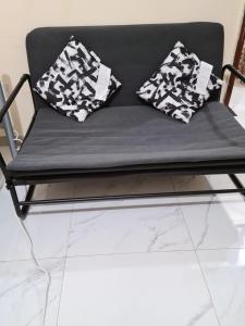 a black bench with two pillows on it at Cozy Corner 2024 in Abu Dhabi
