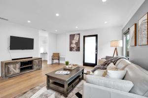 uma sala de estar com um sofá e uma televisão em City Living by AvantStay Large Outdoor Area em Los Angeles