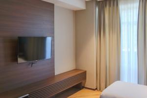 a hotel room with a television on a wall at Nina Palace Hotel in Tbilisi City
