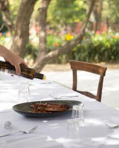 una persona que vierte vino en un plato de comida en una mesa en Villa Battibecco, en Loreto