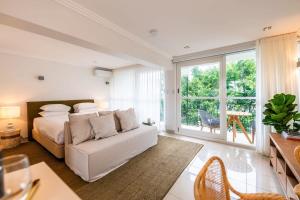 1 dormitorio con cama blanca y sofá blanco en Riverside Studio apartment with parking, en Brisbane