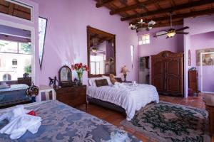 
a bedroom with a bed and a dresser at Garlands Del Rio in Puerto Vallarta
