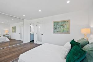 - une chambre blanche avec un lit et un miroir dans l'établissement Dumetz by AvantStay Large Private Outdoor Area, à Los Angeles