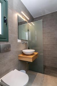 a bathroom with a sink and a toilet at Ageri Hotel in Tinos