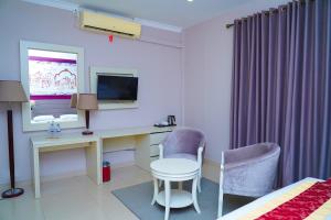 a hotel room with a desk and a tv at Tilko City Hotel Jaffna in Jaffna