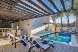 um pátio com uma piscina, uma mesa e cadeiras em Walefield by AvantStay Mid-Wilshire Home Pool em Los Angeles