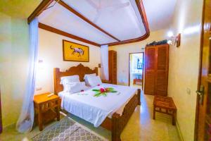 a bedroom with a large bed with a large window at Tembo Golden Beach Apartments in Malindi