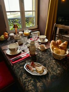 a table with a breakfast of bread and eggs at Camélia in Bayeux