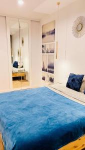a bedroom with a large bed with blue sheets at Rudnickiego, Fort Bema, free parking in Warsaw