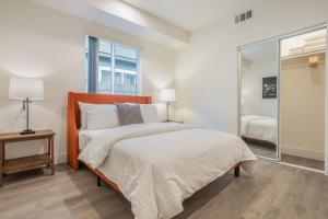 a bedroom with a large bed and a mirror at Periwinkle by AvantStay Walk to Staples Rooftop in Los Angeles