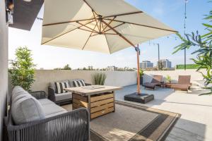 a patio with a table and an umbrella at Periwinkle by AvantStay Walk to Staples Rooftop in Los Angeles