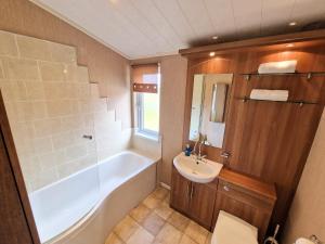 a bathroom with a tub and a sink and a toilet at Benarty 11 with Private Hot Tub - Fife - Loch Leven - Lomond Hills - Pet Friendly in Kelty