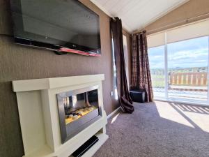 a living room with a fireplace and a tv at Benarty 11 with Private Hot Tub - Fife - Loch Leven - Lomond Hills - Pet Friendly in Kelty