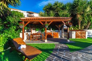 um gazebo de madeira com uma mesa e cadeiras num quintal em Casa Bernarda with Heated Pool em La Cisnera