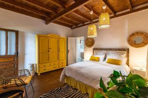 um quarto com uma cama e um armário amarelo em Casa Bernarda with Heated Pool em La Cisnera
