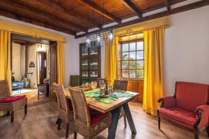 uma sala de jantar com uma mesa de madeira e cadeiras em Casa Bernarda with Heated Pool em La Cisnera