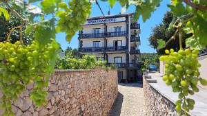 a white building with a balcony on a wall at Apartment ŠTIZ by the sea with an organized beach in Betina
