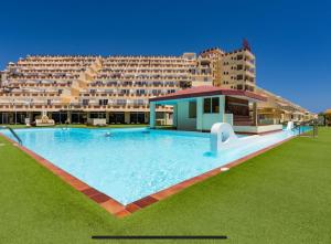 duży basen przed dużym budynkiem w obiekcie Palm Garden Apartment w mieście Morro del Jable