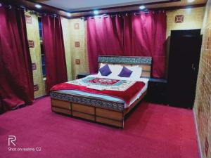 una cama en una habitación con cortinas rosas en Zago Guest House, en Skardu
