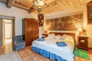 a bedroom with a bed and a painting on the wall at Le Moulin in Saint-Rémy-de-Provence