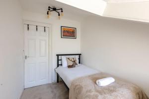 1 dormitorio con cama y puerta blanca en Spacious 3 Bedroom Home In Glasgow - Free Parking en Glasgow