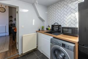 uma cozinha com uma máquina de lavar roupa e um lavatório em Spacious 3 Bedroom Home In Glasgow - Free Parking em Glasgow