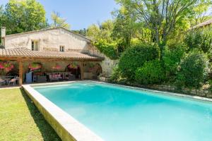 a swimming pool in front of a house at Le Moulin in Saint-Rémy-de-Provence