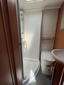 a bathroom with a shower and a toilet and a sink at Camper Rent motorhome Albanian in Tirana