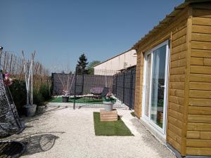 ein kleines Holzgebäude mit einer Terrasse im Hof in der Unterkunft Le Refuge Zen et bien-être bulle in Montpouillan