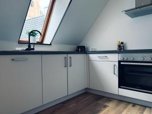 a kitchen with white cabinets and a window at FeWo Vechtelust Geräumig & Zentrumsnah in Nordhorn