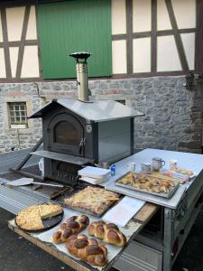 a table with an oven with bread and pastries on it at Bachmanns Ferienwohnung in Schotten