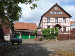 uma casa grande e um edifício com portas verdes em Bachmanns Ferienwohnung em Schotten