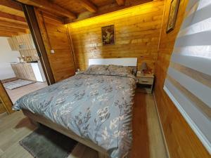 een slaapkamer met een bed in een houten hut bij Apartman Dača in Malo Laole
