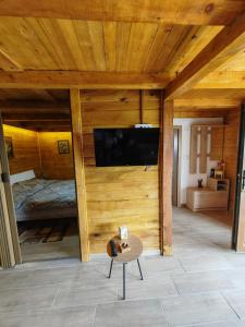 een kamer met een bed en een tv aan de muur bij Apartman Dača in Malo Laole