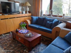 a living room with a blue couch and a coffee table at Vakantie boerderij De Boerenzwaluw in Karl