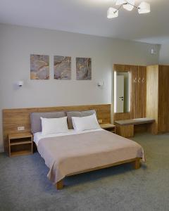 een slaapkamer met een groot bed en 2 tafels bij Duboviy Gai Hotel in Vinnytsya