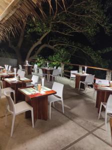 a restaurant with wooden tables and white chairs at Tepanee Beach Resort in Malapascua Island