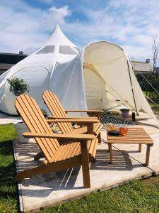 ブラーケルにあるGlamping -Logie Moonlightの庭に椅子とテントを用意しています。
