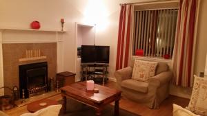 a living room with a couch and a fireplace at The Braes in Stornoway