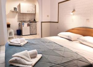 a bedroom with a large bed with towels on it at Eleni Apartments Sant George Beach in Agios Georgios