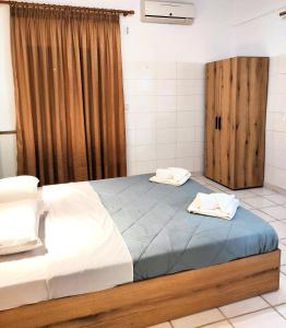 ein Schlafzimmer mit einem großen Bett und einer Holztür in der Unterkunft Eleni Apartments Sant George Beach in Agios Georgios