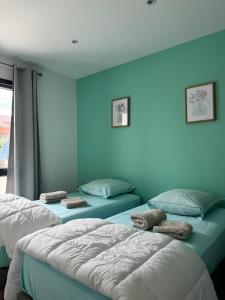 2 camas en una habitación con paredes azules en Villa 1 Les Maisons dans les Vignes, en Joyeuse